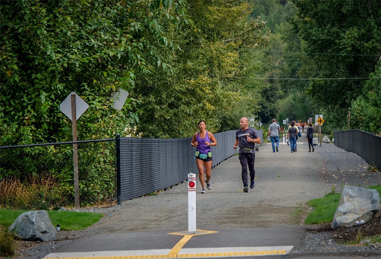 Two runners on the Eastrail trail pavement